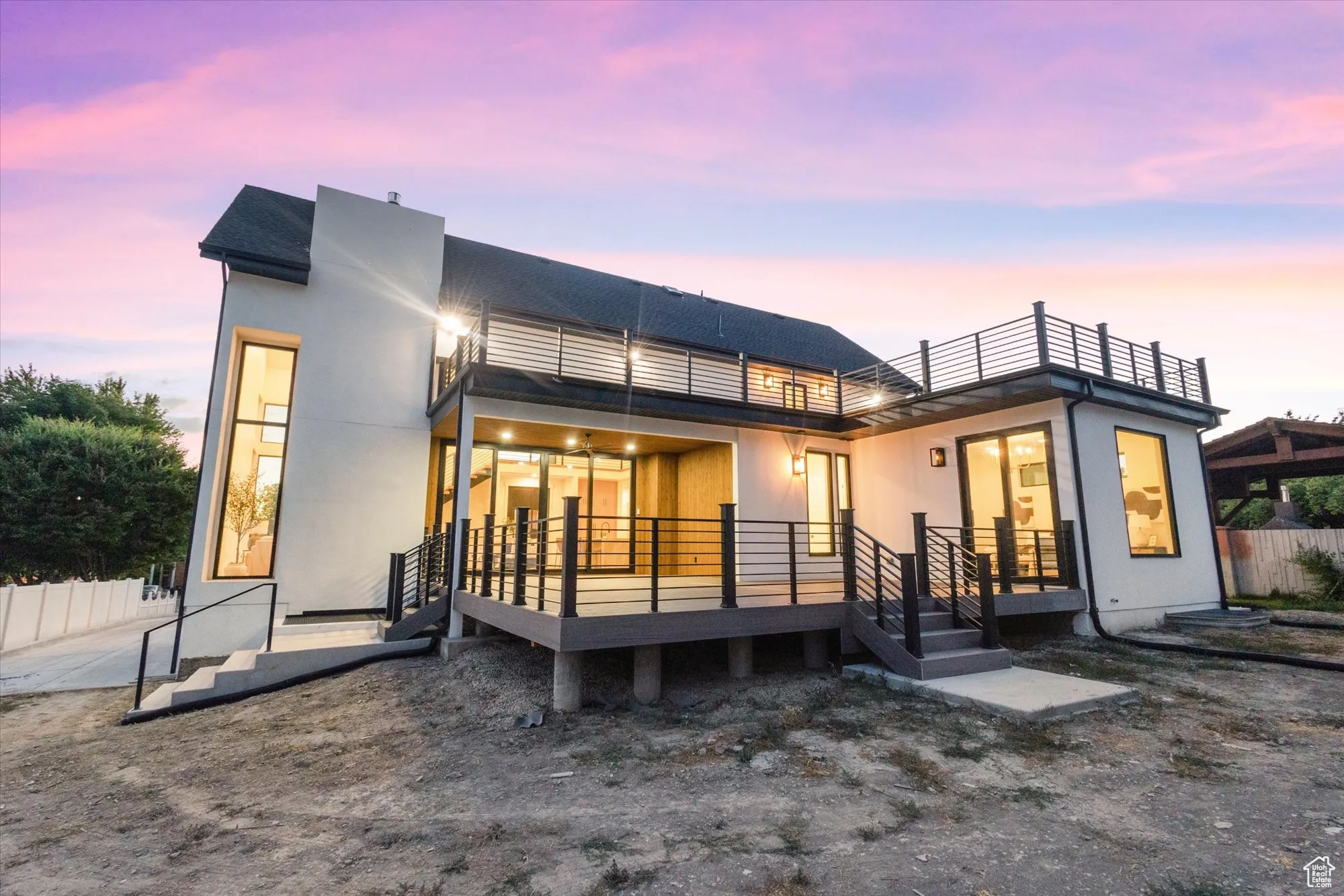 Back of house with a balcony and a wooden deck