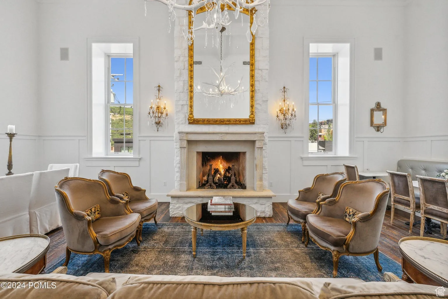 Sitting room featuring a decorative wall, wood finished floors, a wainscoted wall, plenty of natural light, and a high end fireplace