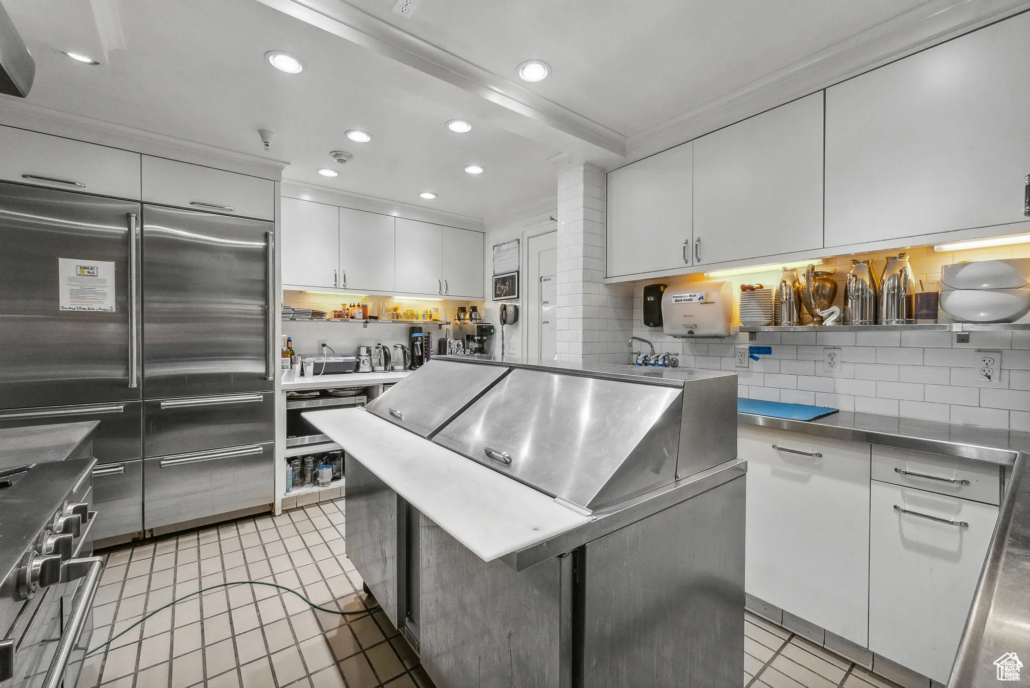 Kitchen with light tile patterned floors, high end appliances, decorative backsplash, white cabinets, and recessed lighting