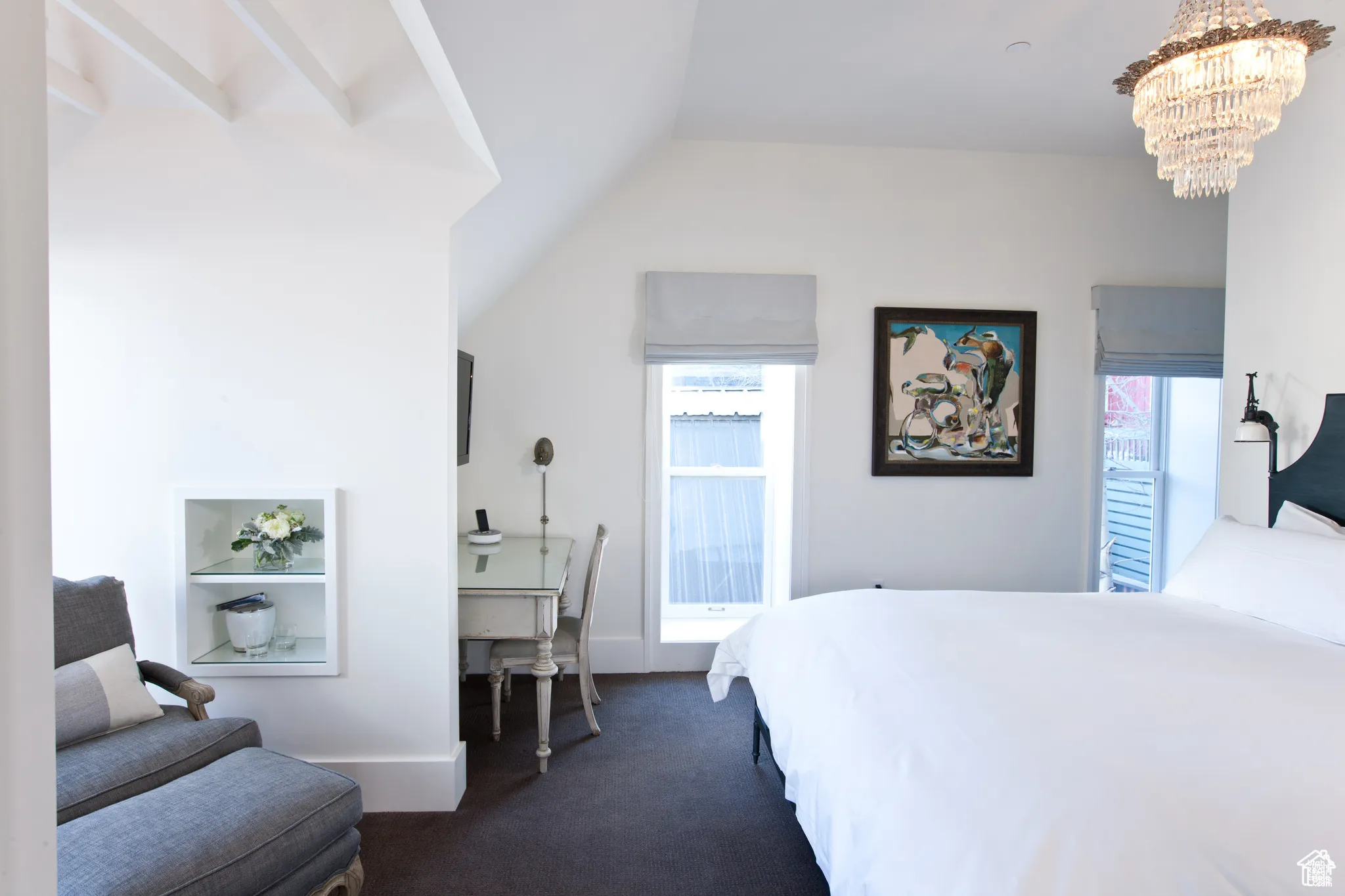Bedroom with a chandelier, dark carpet, and lofted ceiling