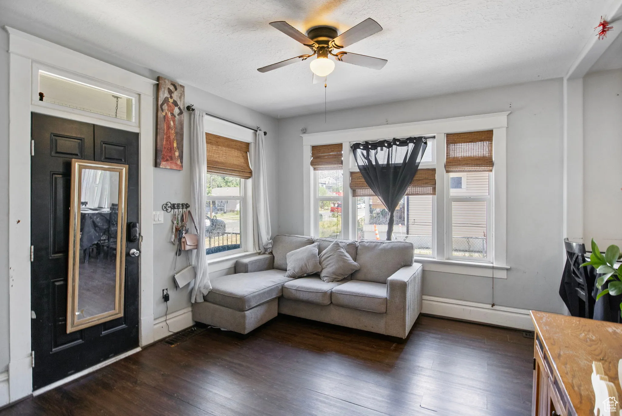 Sitting room featuring dark wood-style flooring, ceiling fan, and baseboard heating