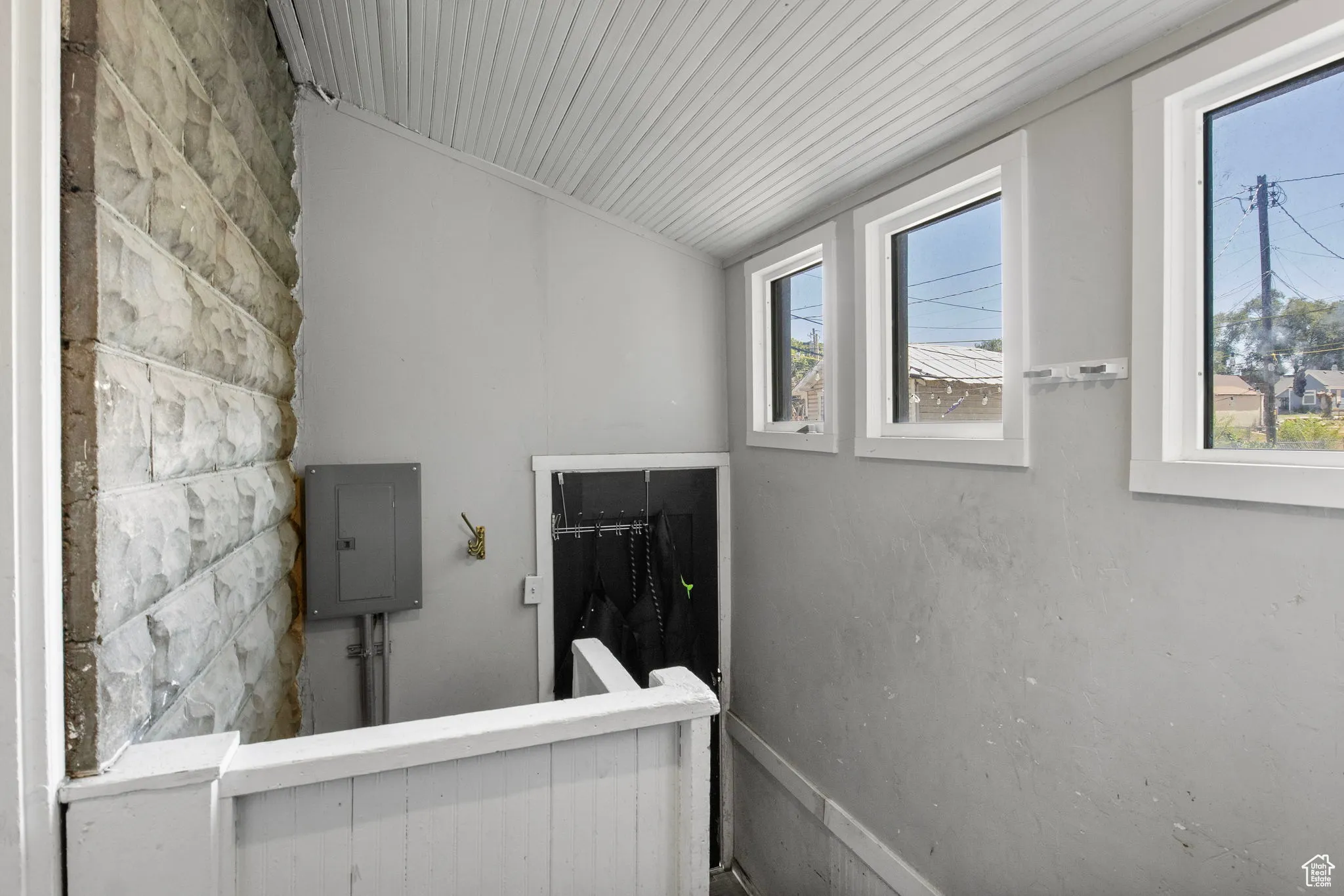 Stairs with electric panel and vaulted ceiling