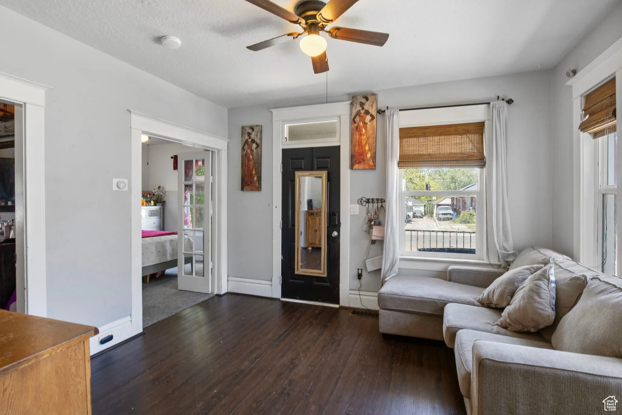 Living area with dark wood finished floors, ceiling fan, and a textured ceiling