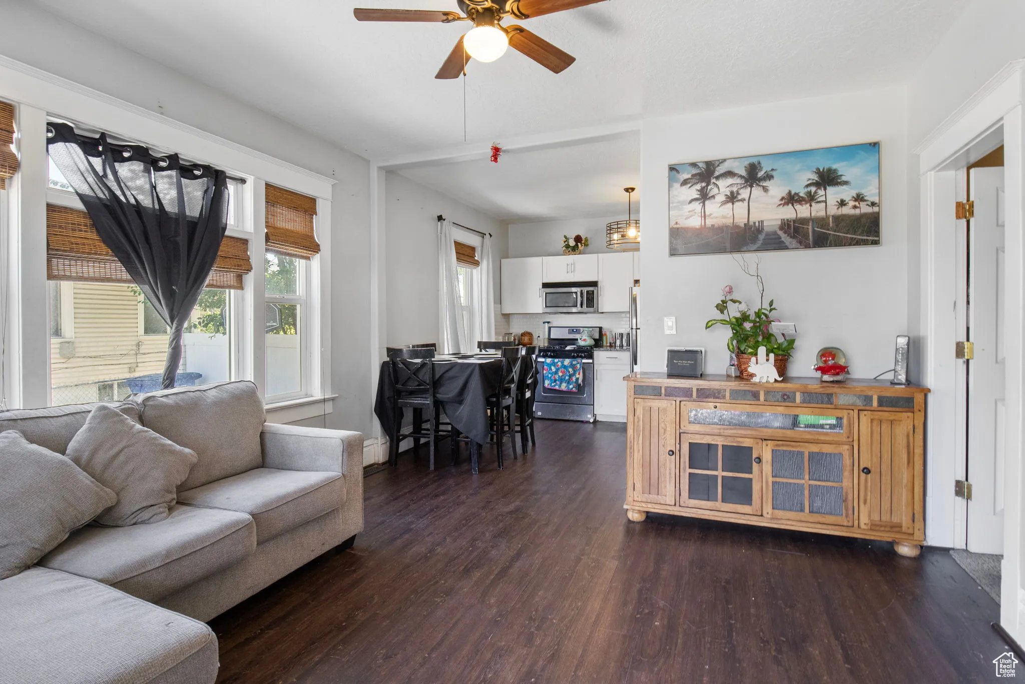 Living area with dark wood-type flooring and a ceiling fan