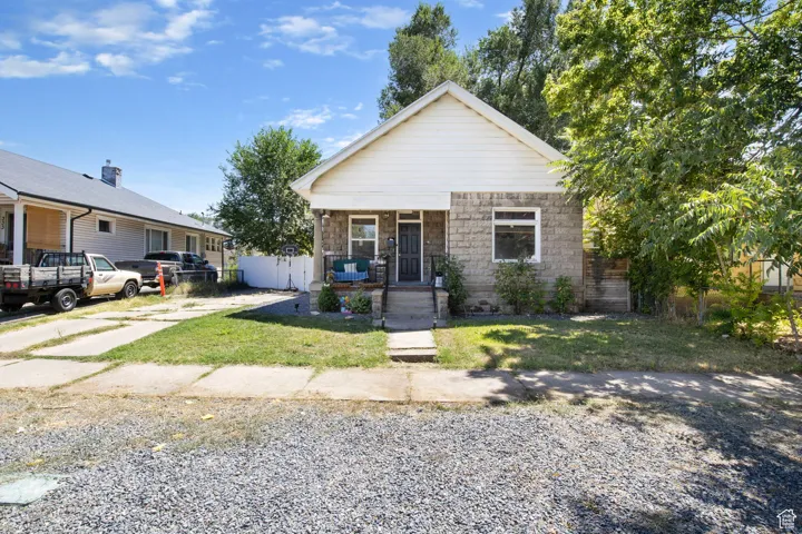 Bungalow featuring a porch and stone siding