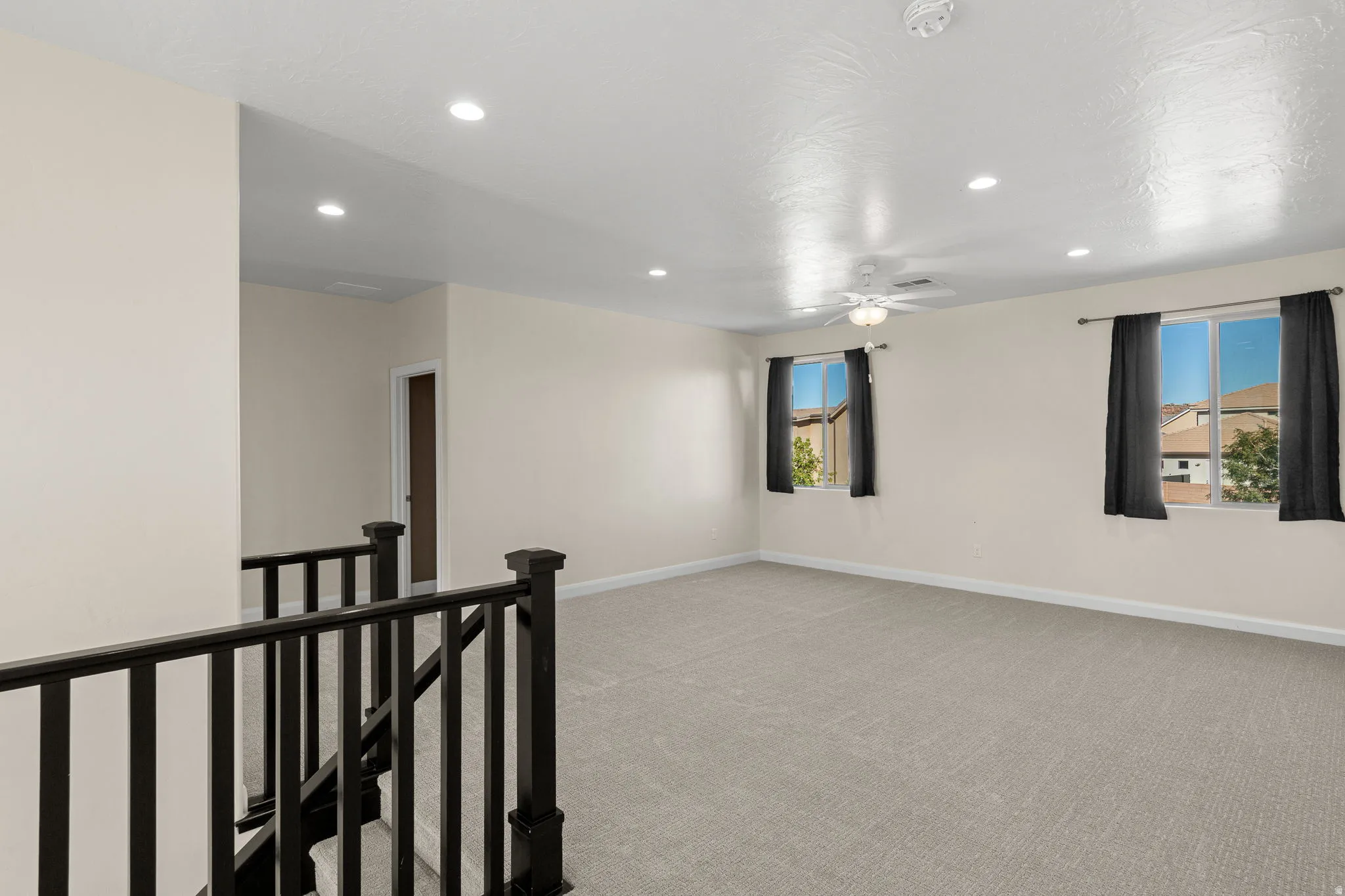 Empty room with light carpet, recessed lighting, a ceiling fan, and a smoke detector