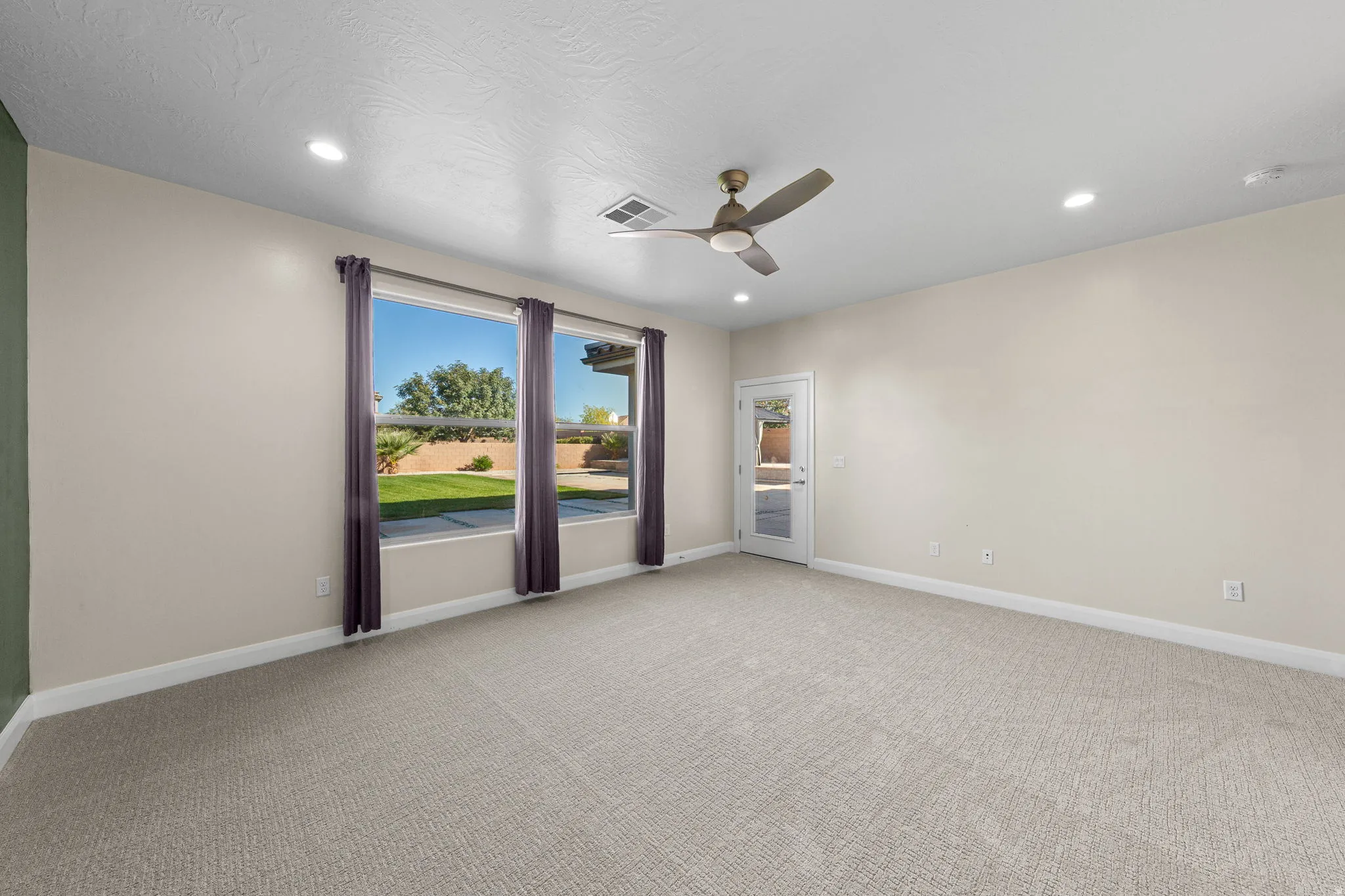 Unfurnished room featuring light colored carpet, ceiling fan, and recessed lighting