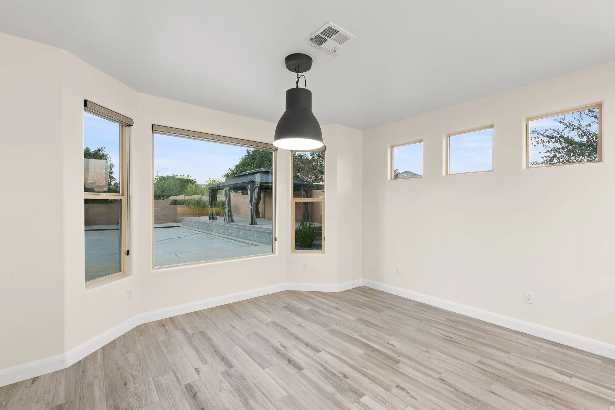 Unfurnished dining area featuring light wood-type flooring and baseboards