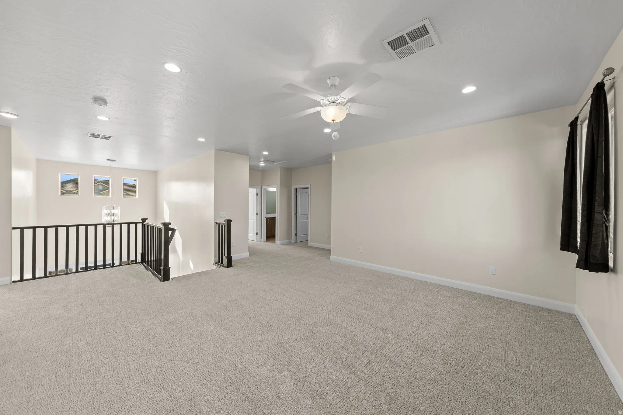 Spare room featuring light carpet, ceiling fan, and recessed lighting