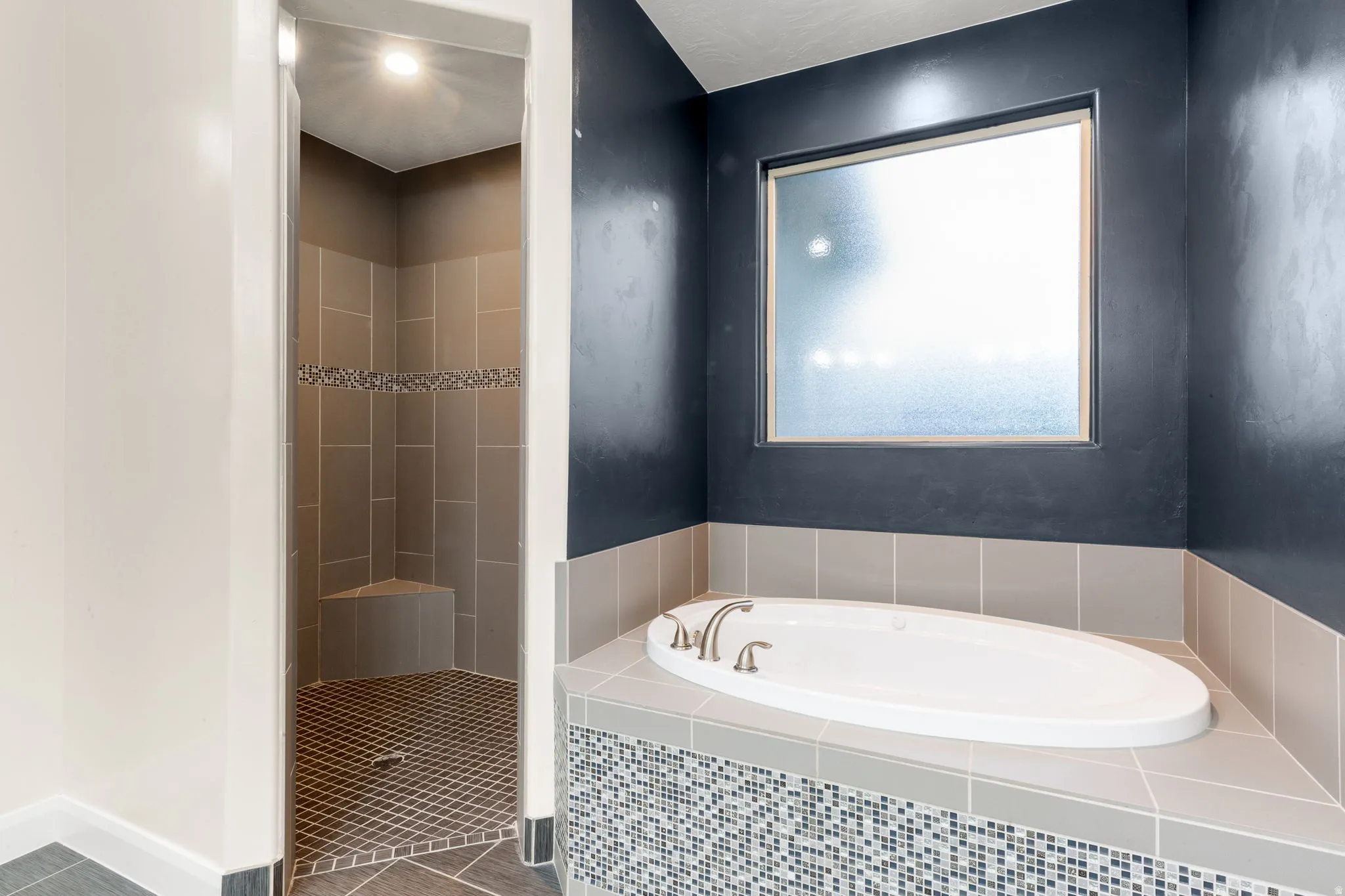 Bathroom with a bath, a shower stall, and tile patterned floors