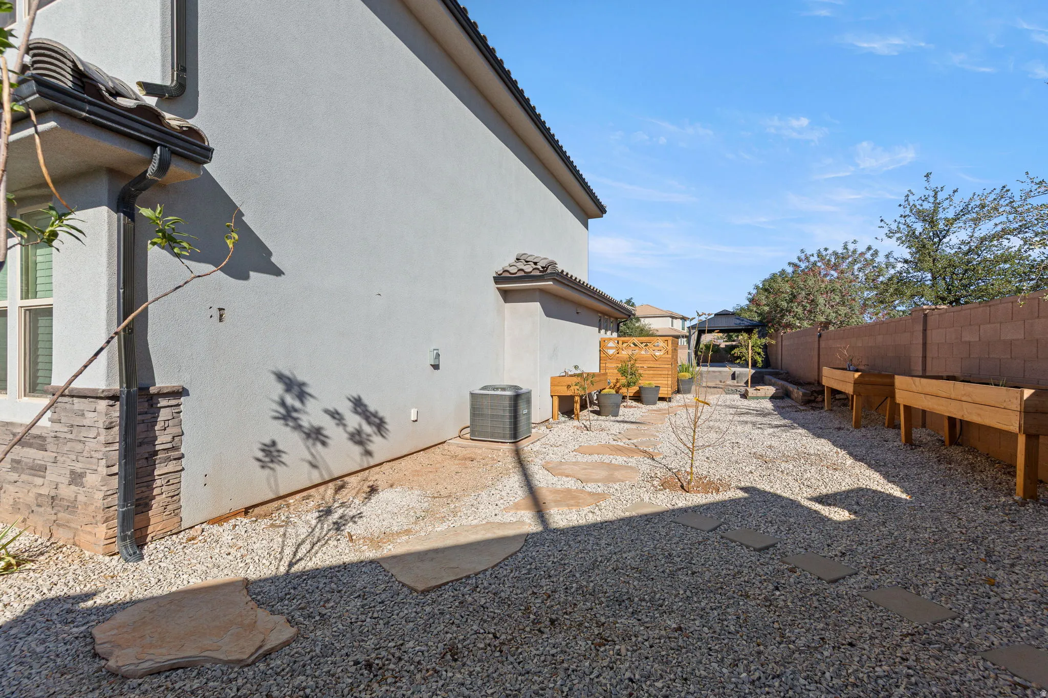 Back of property with a fenced backyard, stucco siding, a patio, a gazebo, and a tile roof