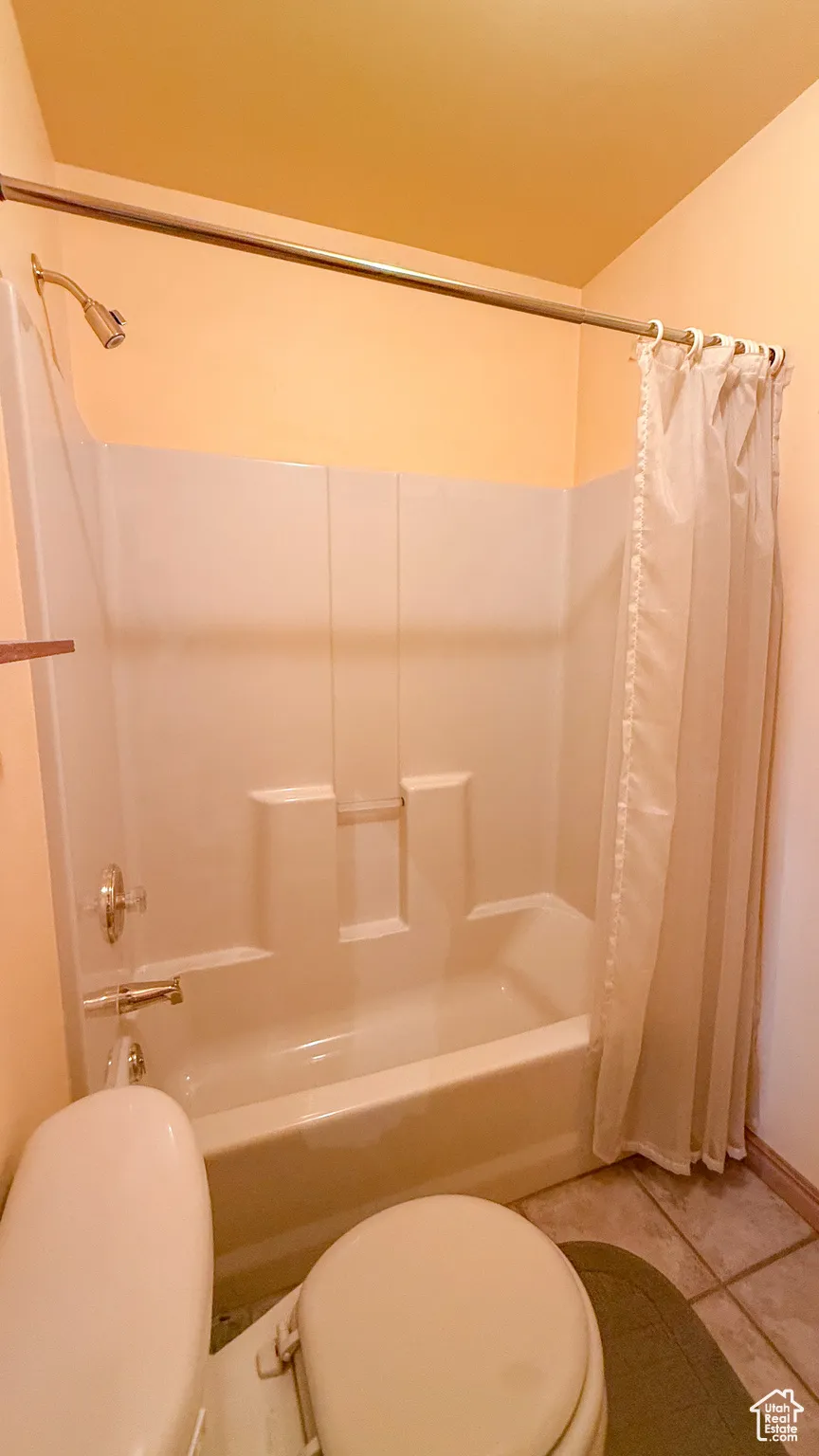 Bathroom with shower / bath combination with curtain and tile patterned flooring