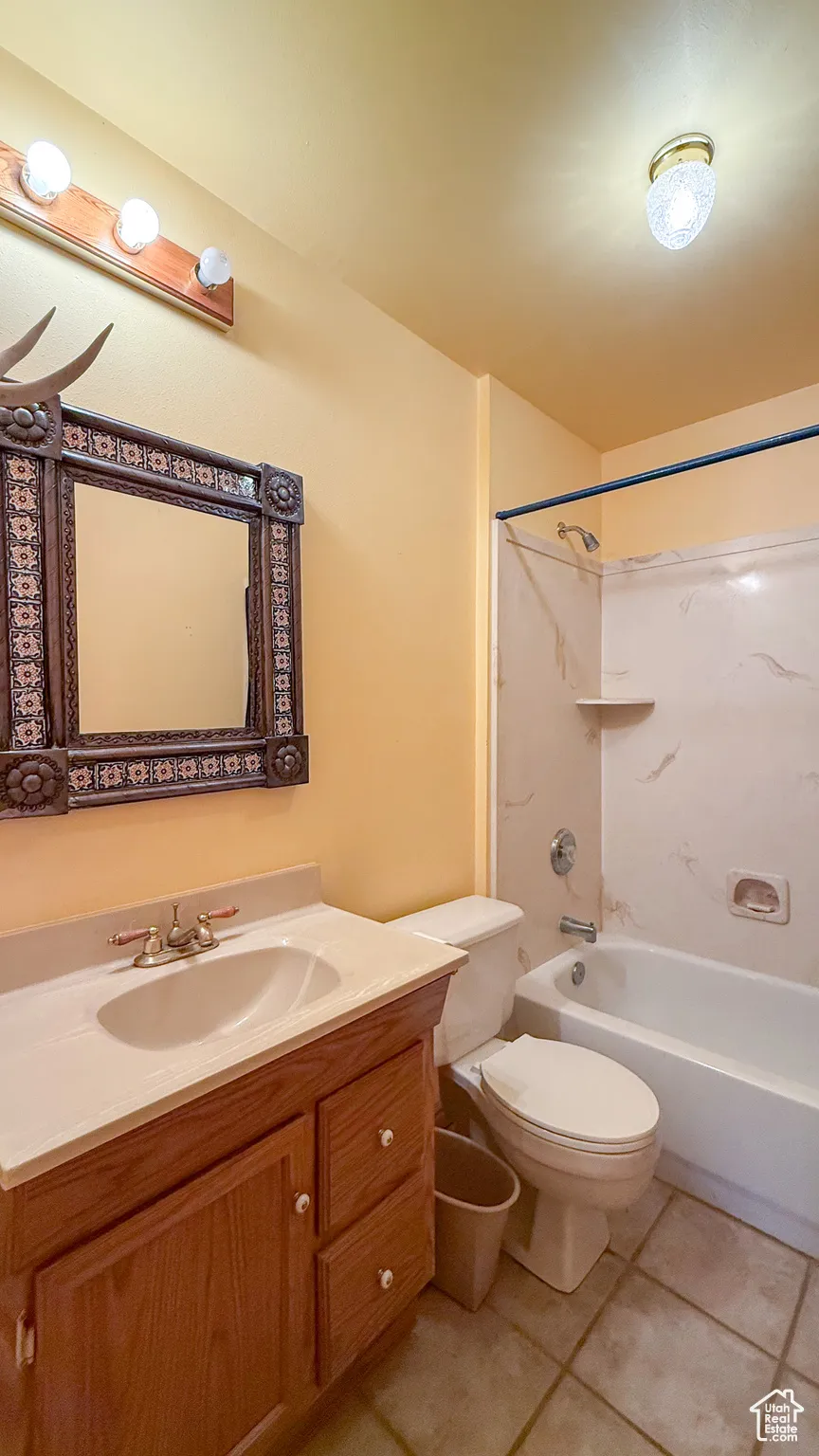 Bathroom featuring tile patterned flooring, vanity, and shower / tub combination