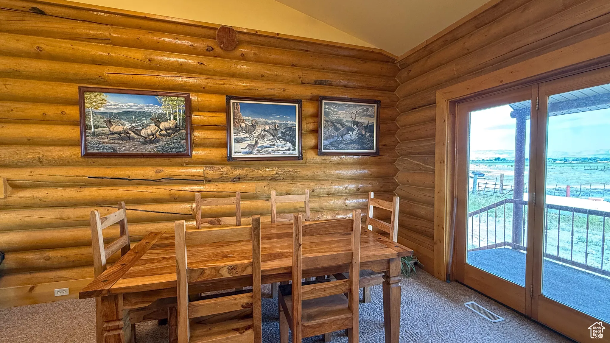 Unfurnished dining area featuring lofted ceiling and carpet