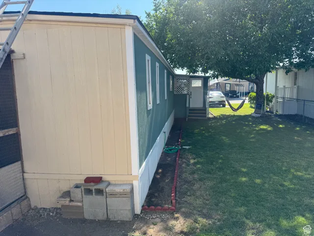 View of side of home featuring entry steps and a lawn