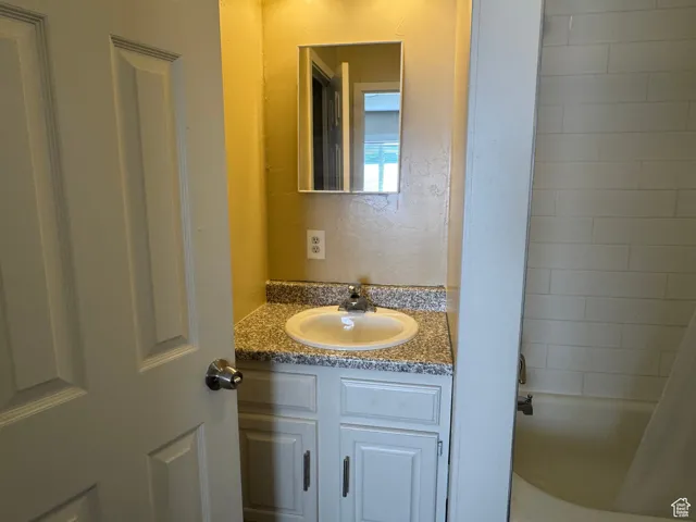 Bathroom with vanity and shower / bath combination with curtain