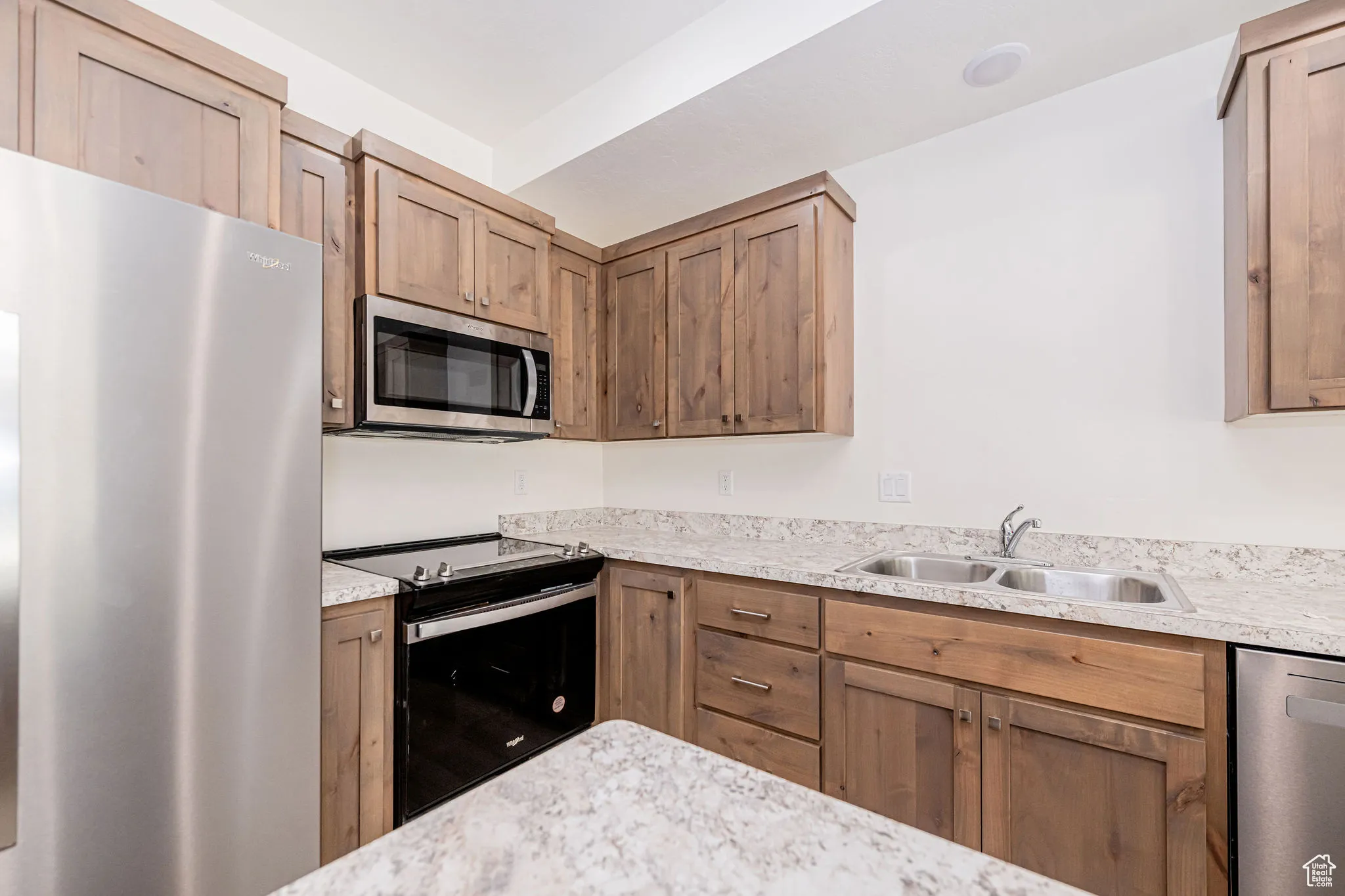 Kitchen with stainless steel appliances and light countertops