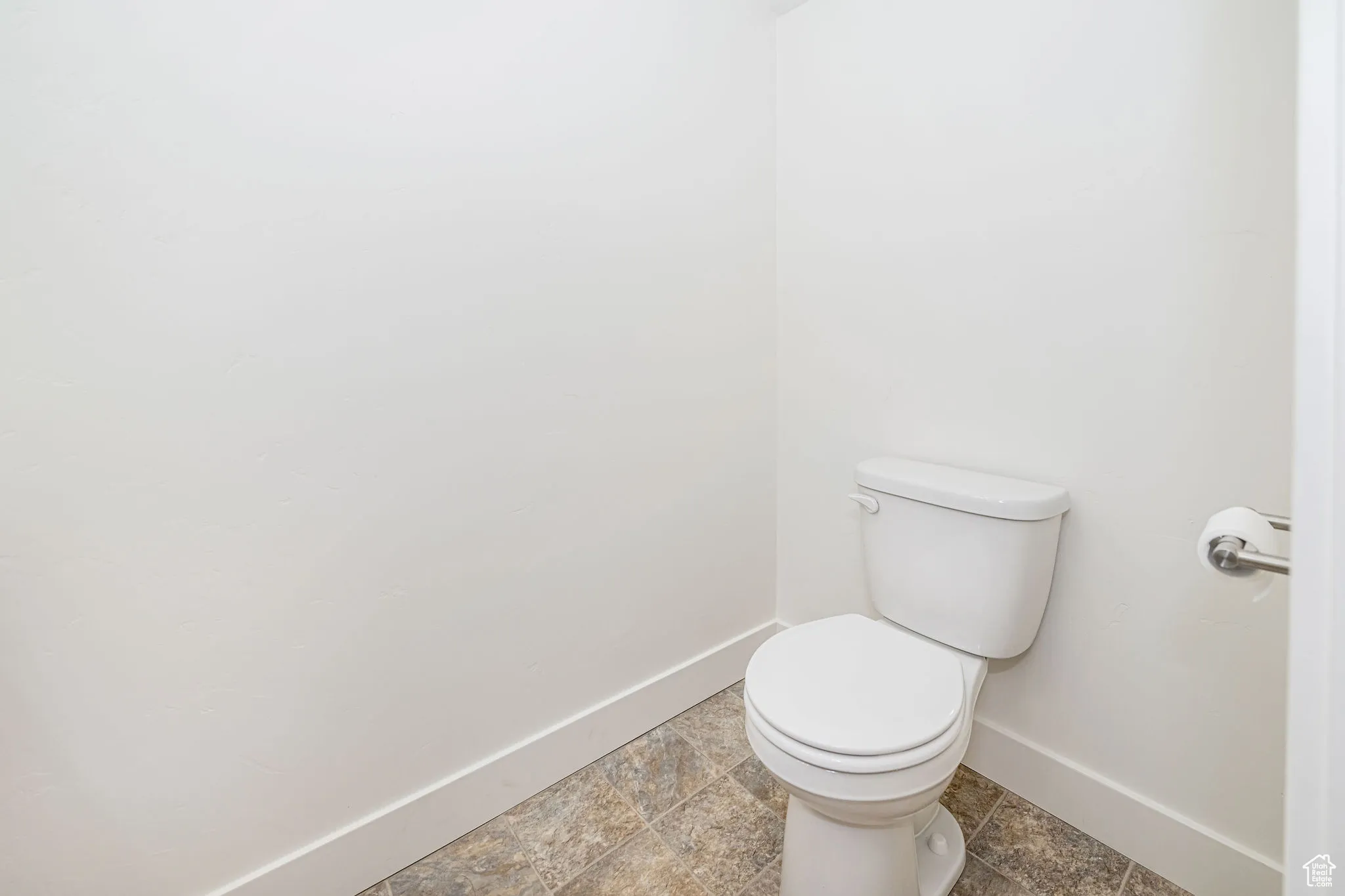 Bathroom featuring baseboards and toilet