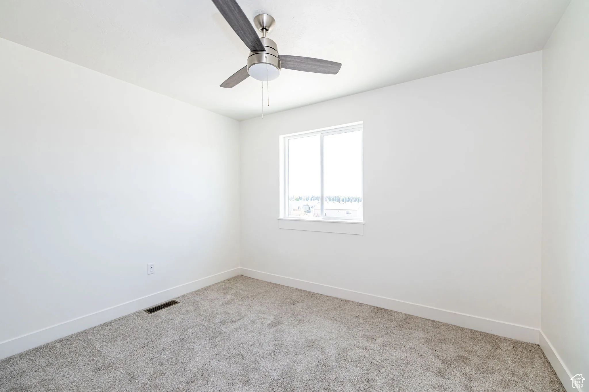 Empty room featuring carpet floors and ceiling fan