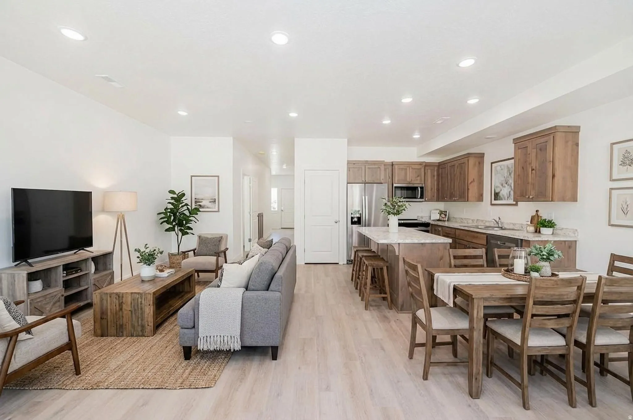 Living area with light wood-type flooring and recessed lighting