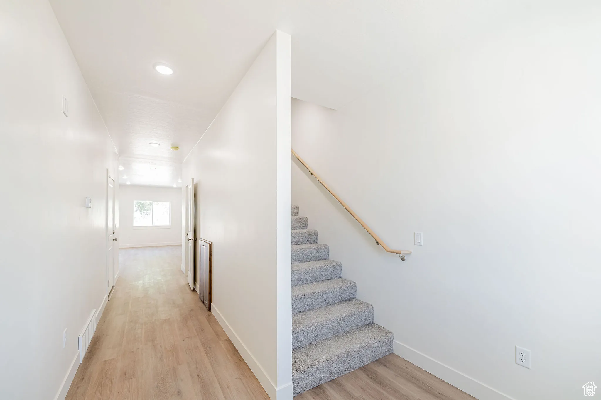 Stairs with wood finished floors and recessed lighting
