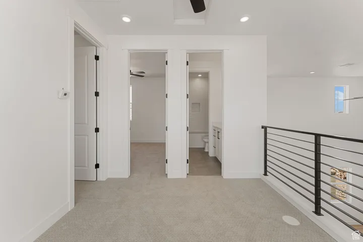 Corridor with light carpet, recessed lighting, and an upstairs landing