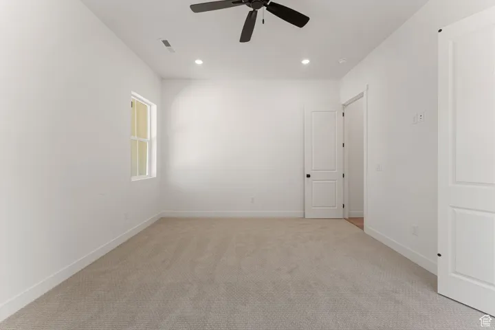 Unfurnished room featuring light carpet, recessed lighting, and a ceiling fan