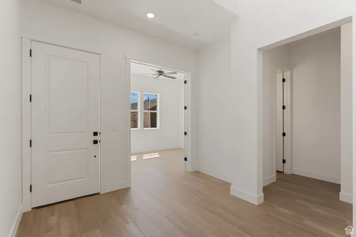 Entryway featuring light wood-style flooring, a ceiling fan, and recessed lighting