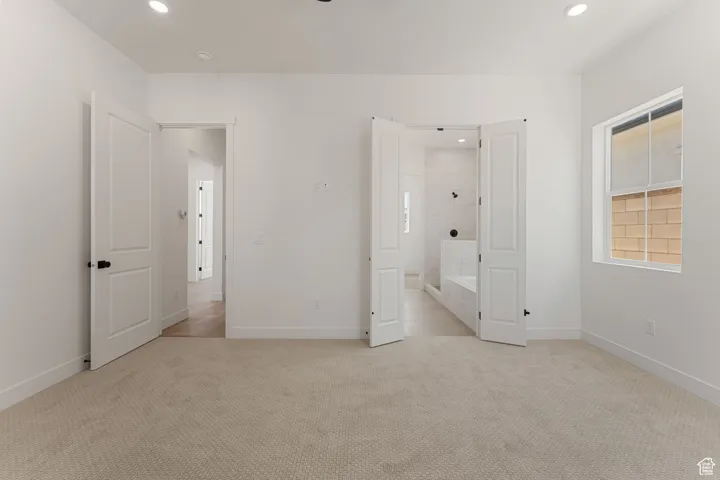 Unfurnished bedroom featuring recessed lighting and light carpet