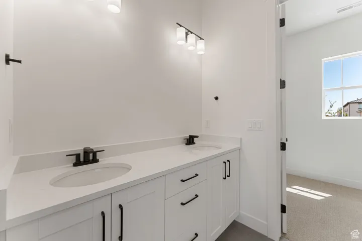 Bathroom with baseboards and double vanity