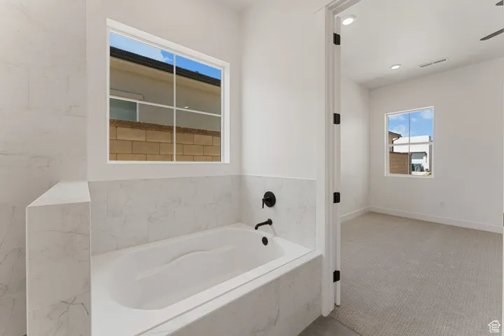 Bathroom featuring a garden tub and recessed lighting