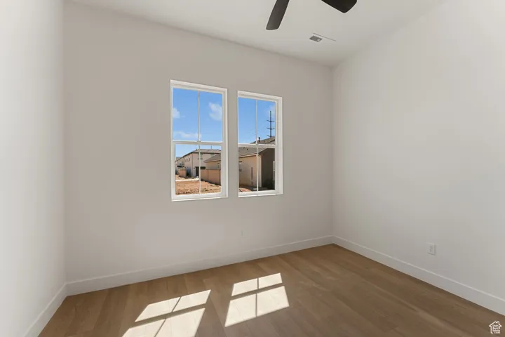 Empty room featuring wood finished floors and ceiling fan