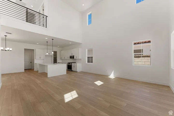 Unfurnished living room featuring light wood-type flooring, healthy amount of natural light, and recessed lighting