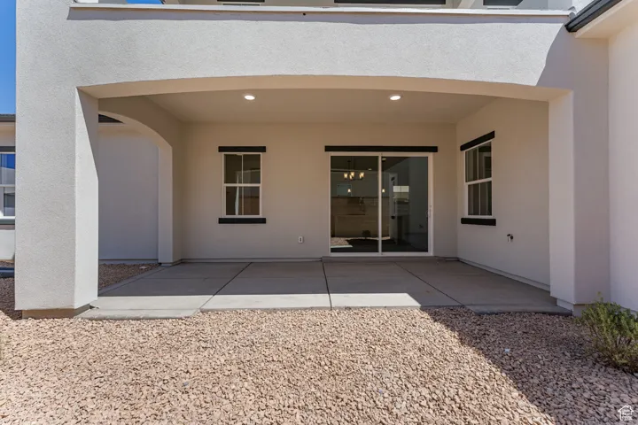Back of house with a patio and stucco siding