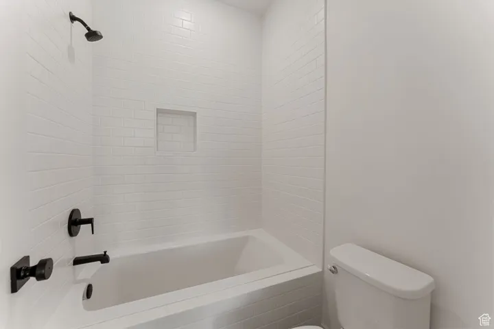 Full bath featuring toilet and shower / washtub combination