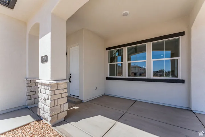 Property entrance with stone siding and stucco siding