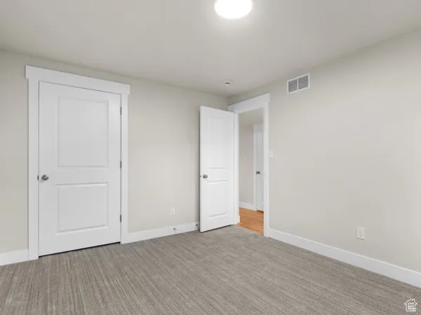 Unfurnished bedroom featuring carpet floors and baseboards