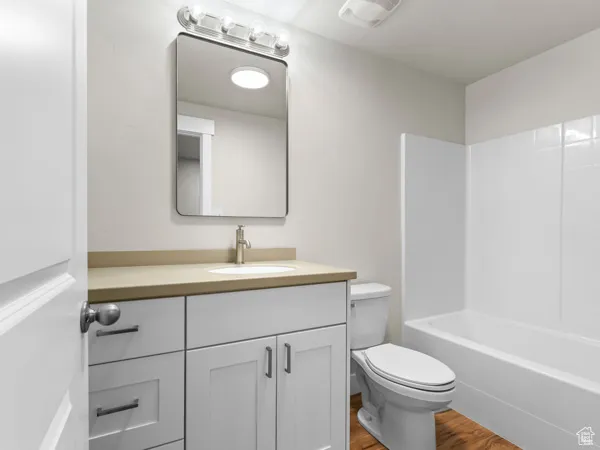 Full bathroom featuring vanity, wood finished floors, and bathtub / shower combination