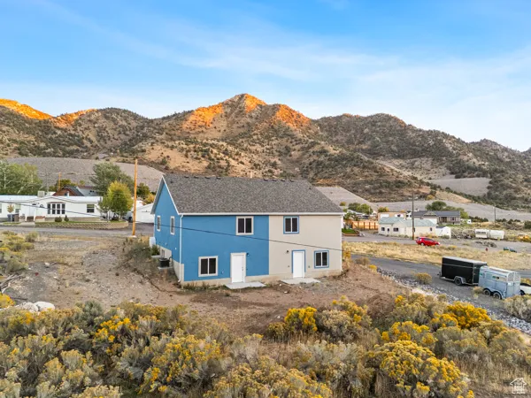 Rear view of house with stucco siding and a mountain view