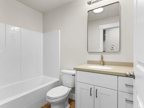 Full bath with vanity, shower / bathtub combination, and wood finished floors