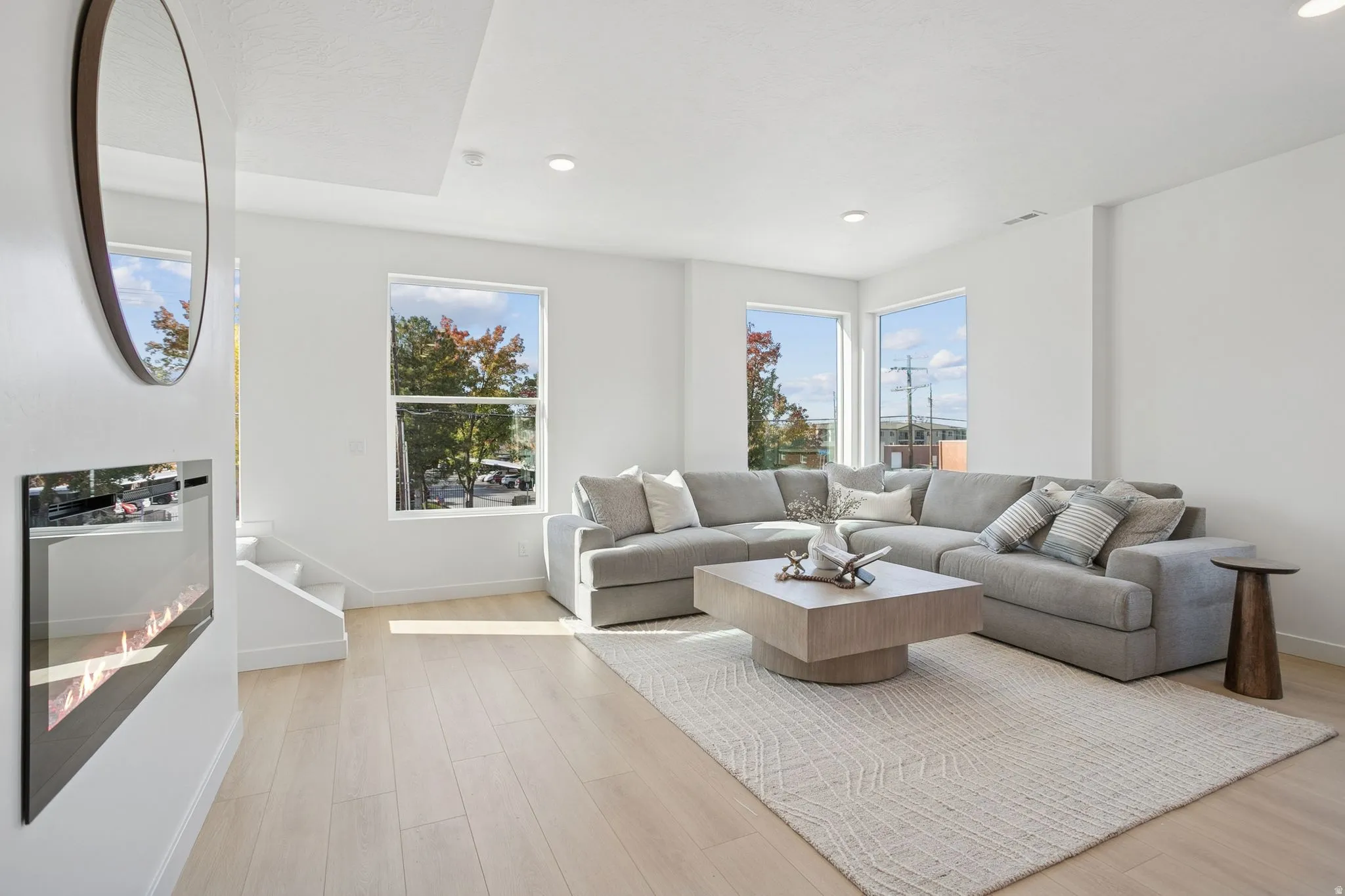 Living area with light wood-style flooring, stairs, and recessed lighting