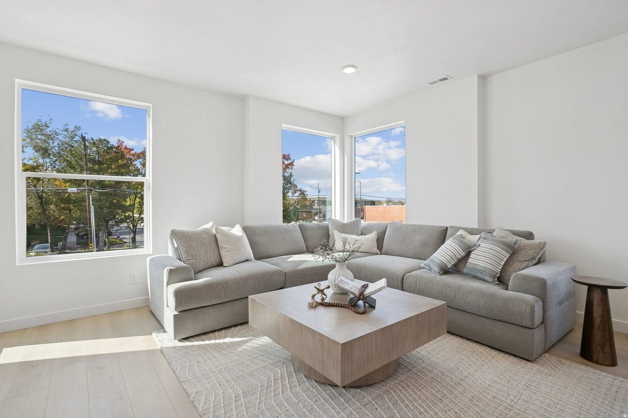 Living room featuring healthy amount of natural light, light wood-style flooring, and recessed lighting
