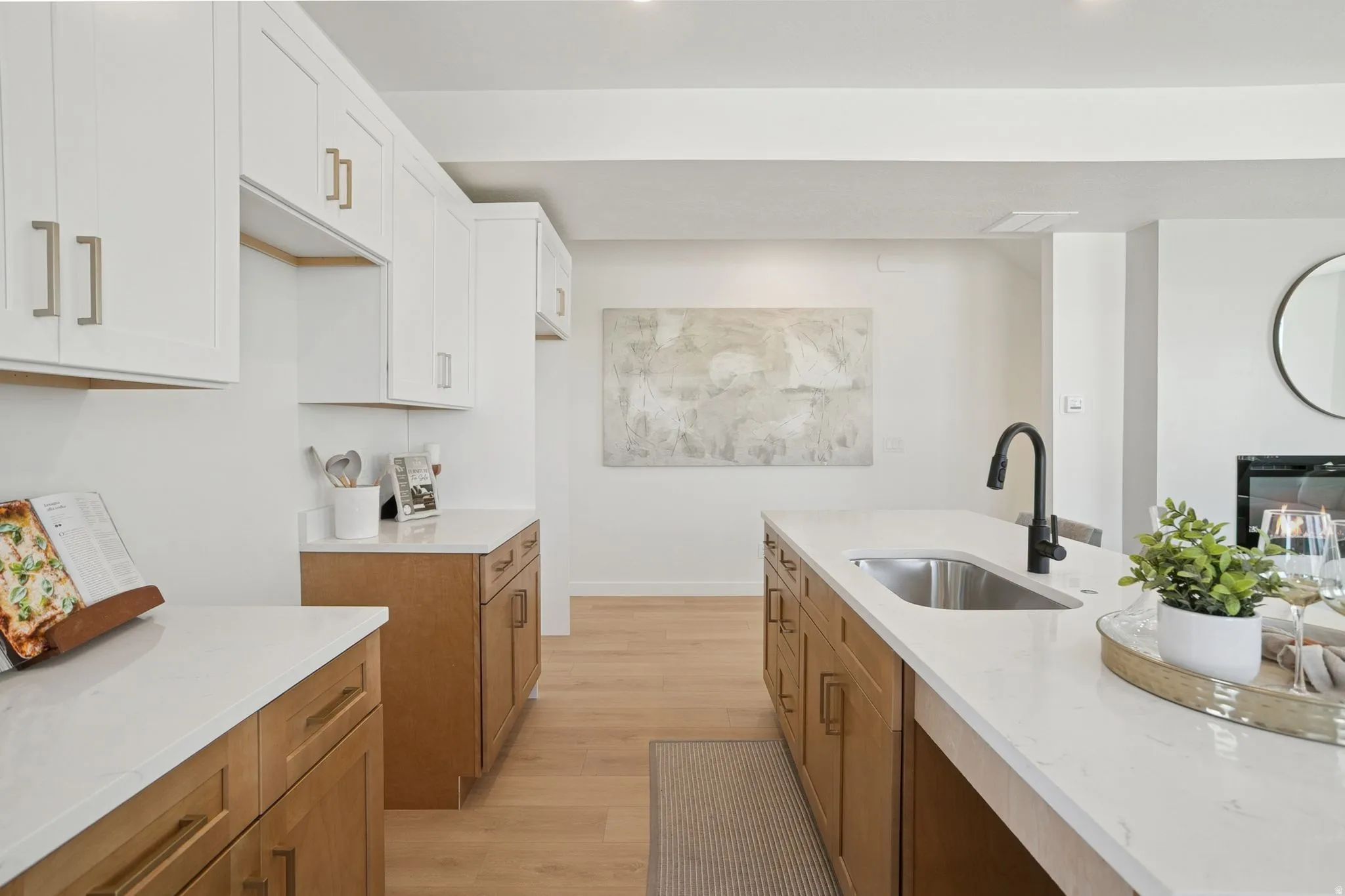 Kitchen featuring light stone countertops, light wood-type flooring, and white cabinetry