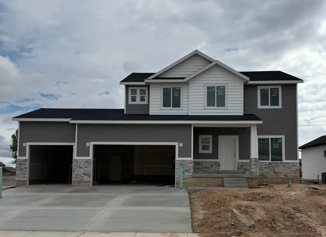 View of front of property featuring stone siding and concrete driveway
