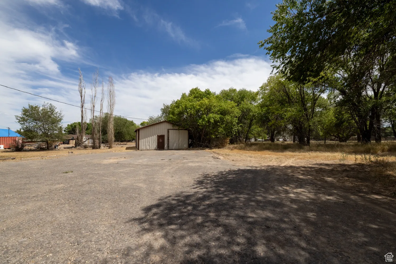 View of yard featuring an outbuilding, a detached garage, and a pole building