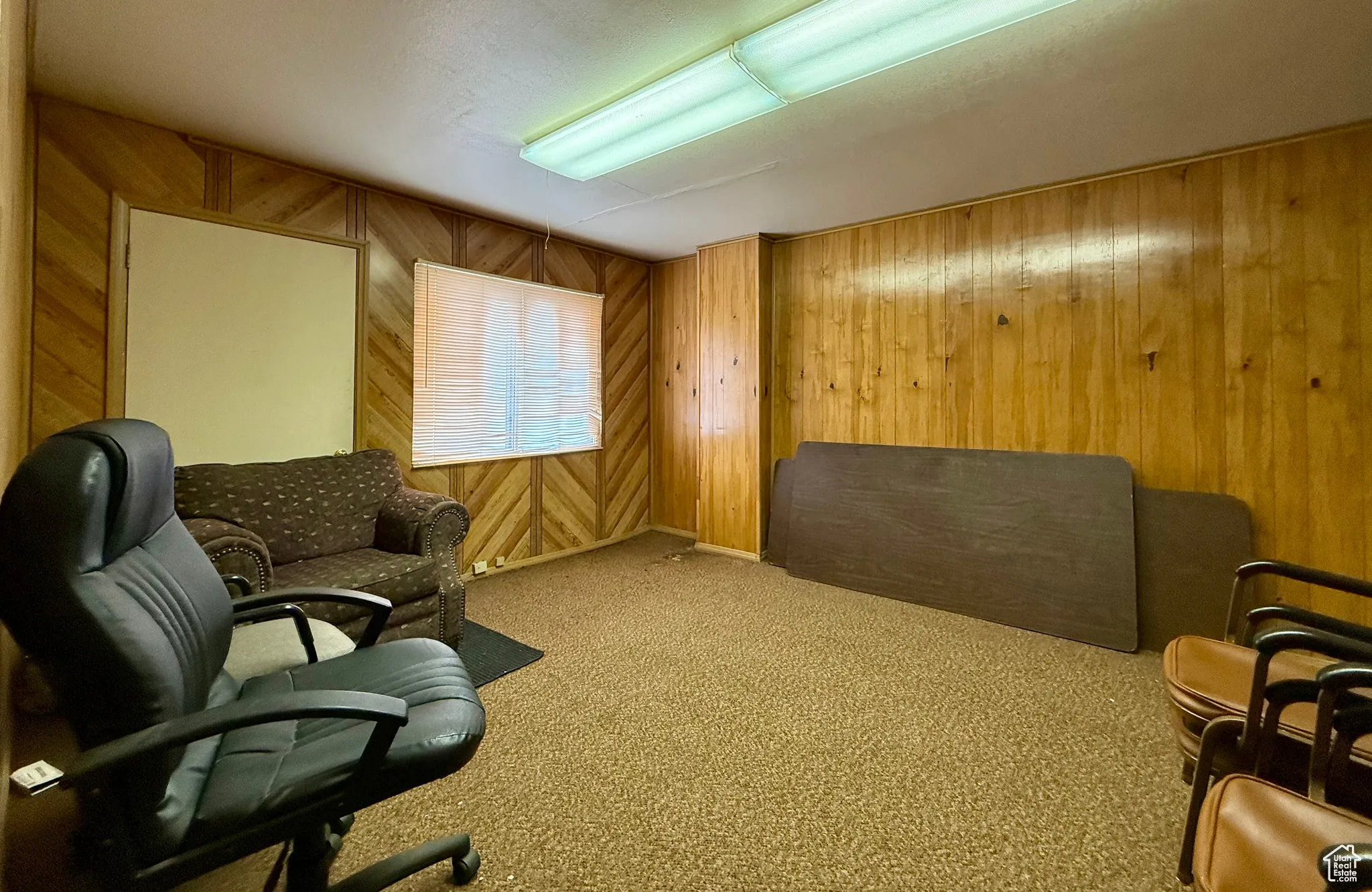 Office area with wood walls and carpet floors