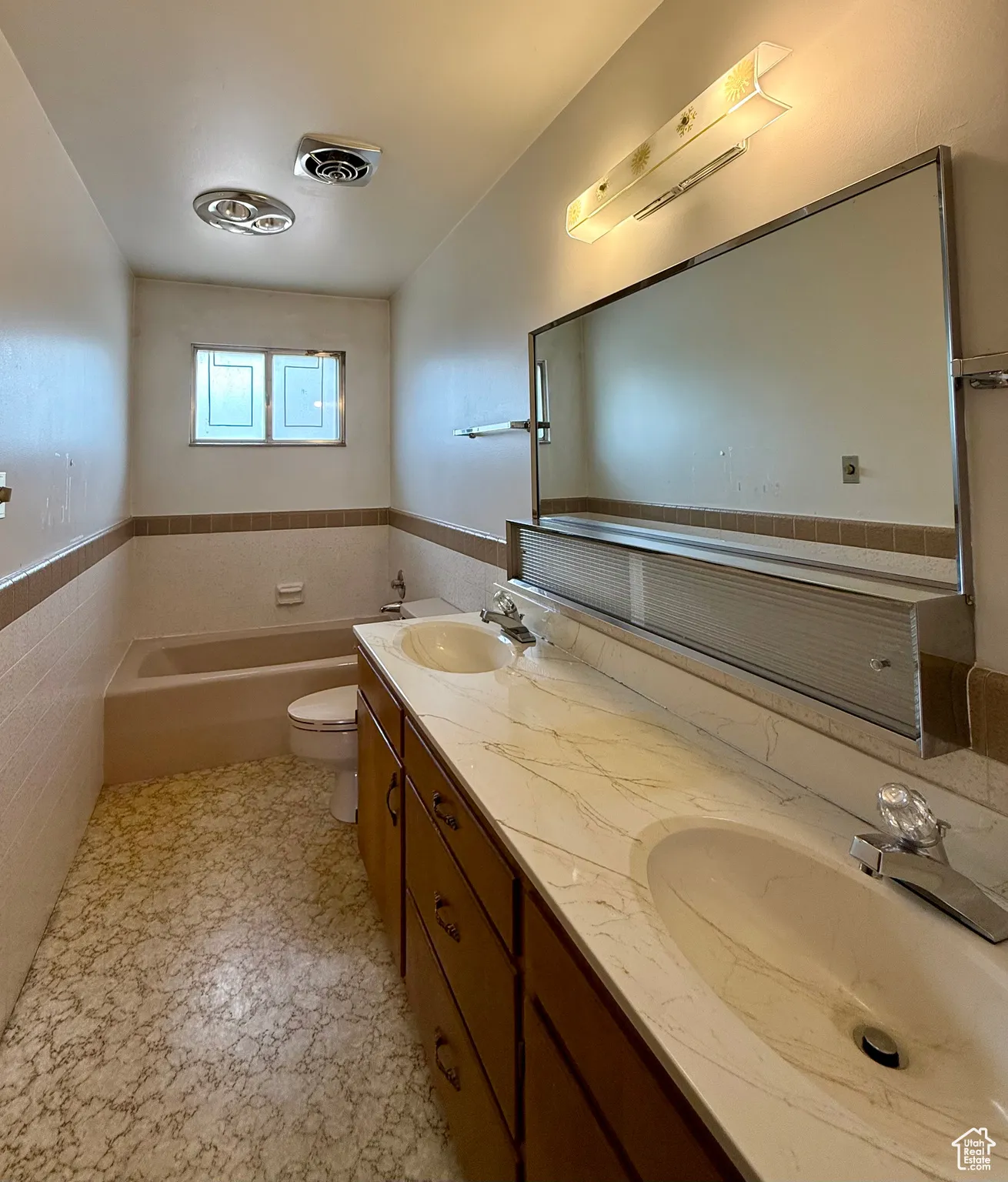 Bathroom featuring a garden tub, wainscoting, and tile walls