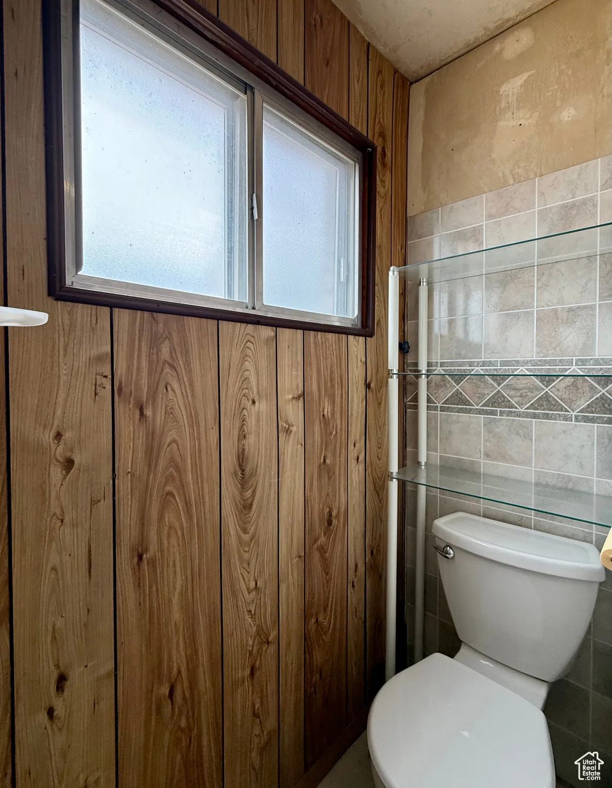 Half bathroom with tile walls and toilet