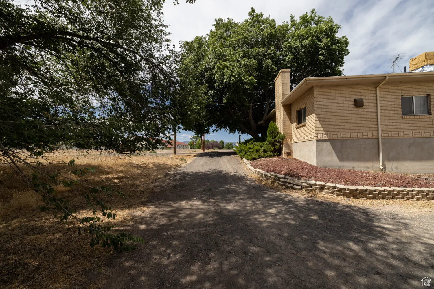 View of property exterior featuring a chimney and brick siding