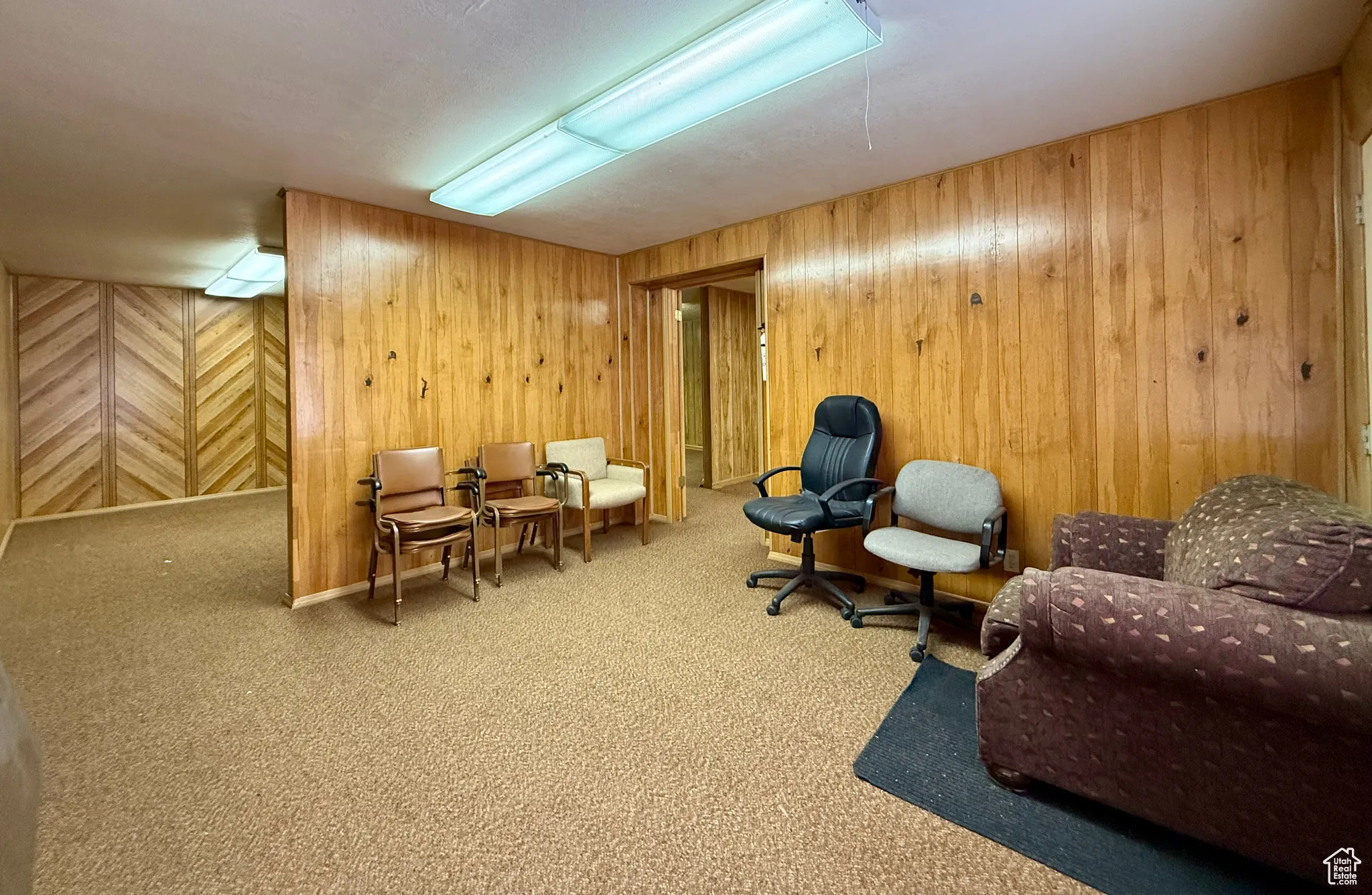Living area with carpet floors and wooden walls